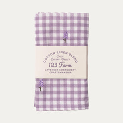 Purple gingham fabric with embroidered lavender and text on a white background