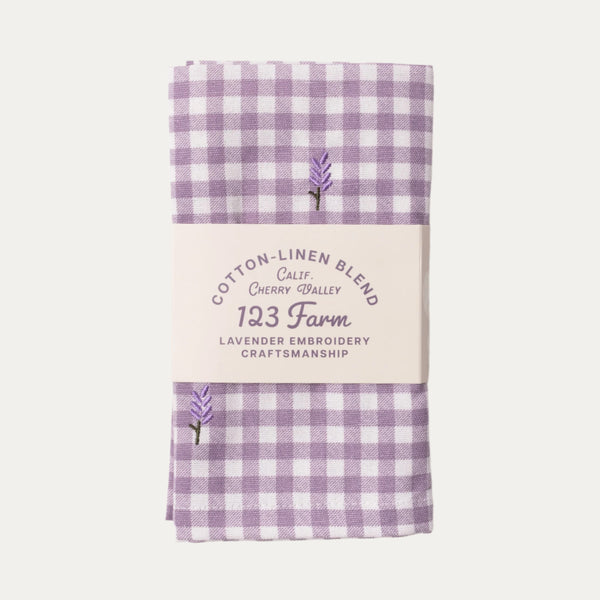 Purple gingham fabric with embroidered lavender and text on a white background